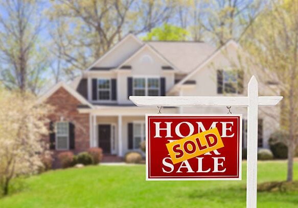 Sold Home For Sale Real Estate Sign and Beautiful New House. Sold Home For Sale Real Estate Sign and Beautiful New House.